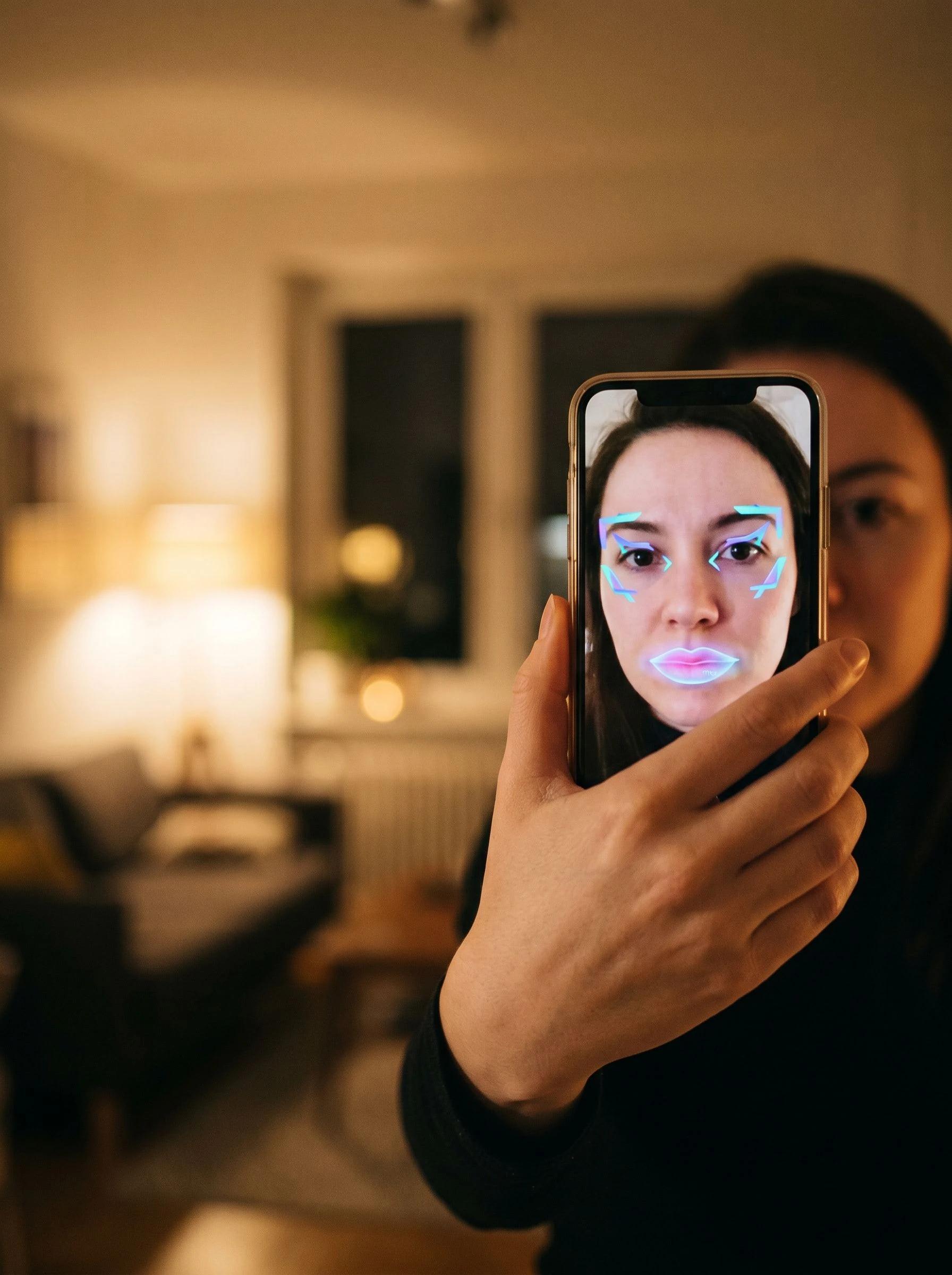 Face-tracked AR filter mid-use with a branded cosmetic overlay visible on a phone screen