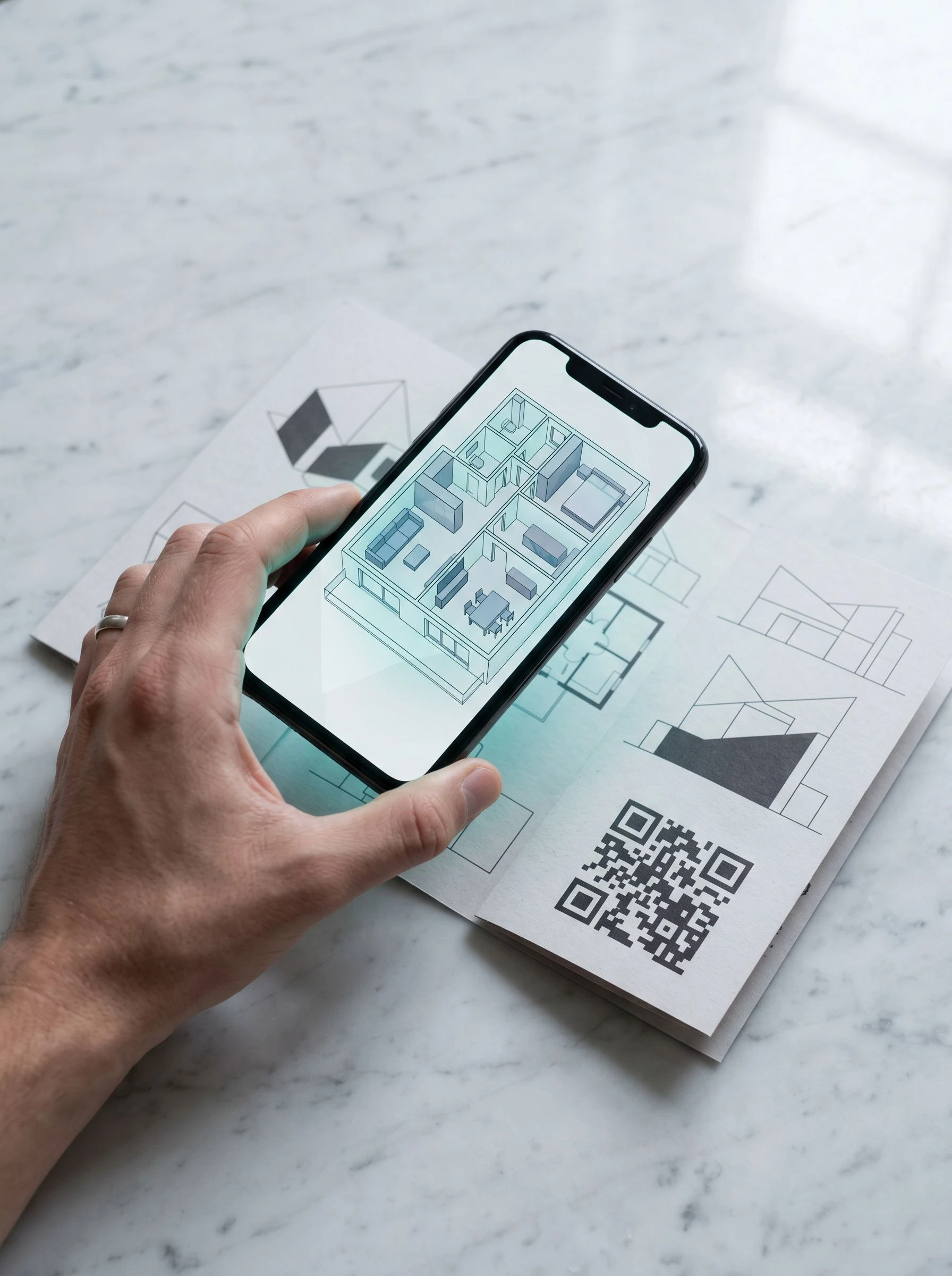 Phone showing an AR floor-plan overlay activated from a printed property brochure